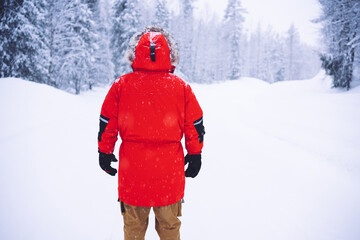 Fototapeta na wymiar Unrecognizable man in warm outerwear standing on snowy road