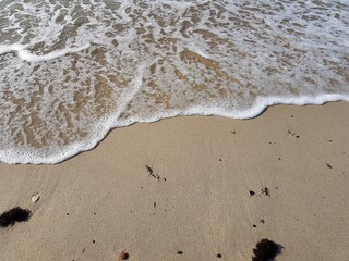 Sea waves roll onto the sandy shore