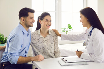 Female doctor consulting young couple patients in fertility clinic about IVF or IUI. Doctor...