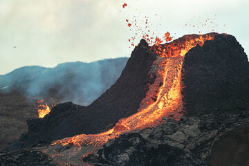 Volcanic eruption in Iceland, lava bursting from the volcano. 
Bright yellow magma. 