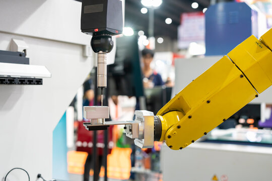 automatic coordinate measurement machine (CMM) during inspection precision part of engine for industrial in manufacturing process with robot arm and auto grip clamp for transfer