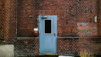 brick wall and blue metal safety door