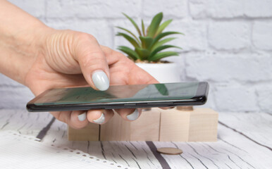 Women holding a phone in their hand, sending a message or looking at market quotes, business concept
