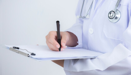 Doctor hand taking note information of patient in paperwork checklist on clipboard with white background