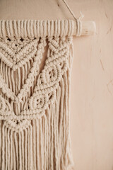 Panel macrame fragment on the wall. Home decor in boho style. Close-up.