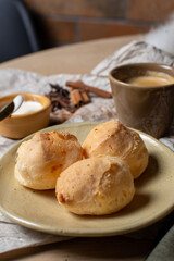 pão de queijo brasileiro caseiro servido com café em mesa rustica