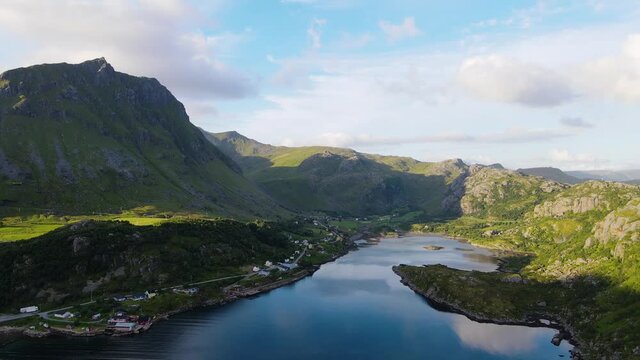 Aerial drone shot overlooking a mountainside fisherman village, in Lofoten, Norway, during golden hour