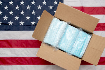 Fototapeta na wymiar Box of medical masks on the USA flag