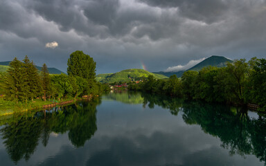 reflection of trees and hills in river