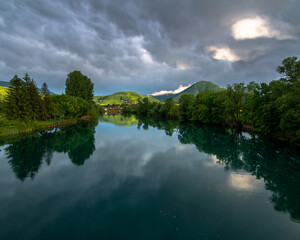 reflection of trees and hills in river