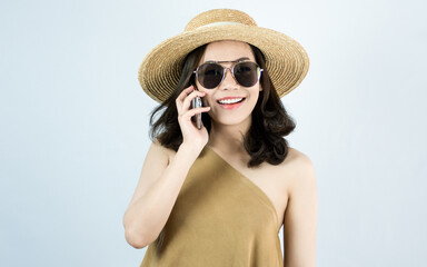 Asian woman talking on mobile phone and standing on white background