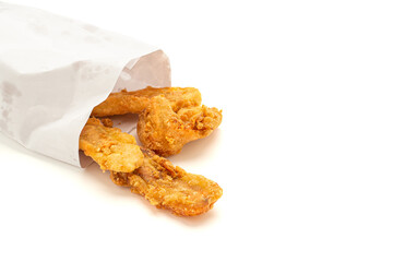 Fried bananas pouring outside of a paper bag placed on white background