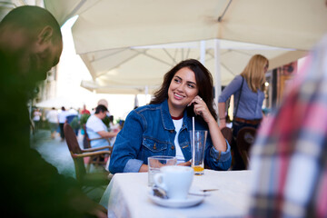Smiling young female having conversation in cafe