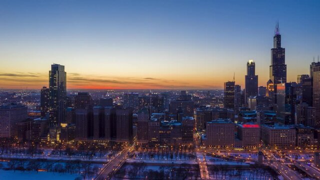 Urban Skyline of Chicago Loop at Sunset in Frosty Winter Evening. Blue Hour. Aerial Hyper Lapse, Time Lapse. United States of America. Drone Flies Sideways