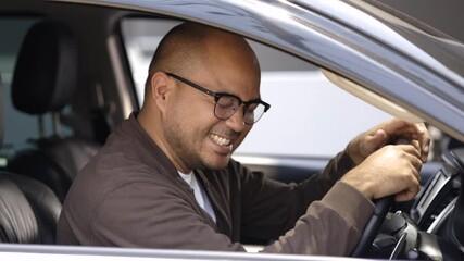Young asian men around 30 getting new car. He very happy and excited. He get in car hugging steering wheel of the car and touching every detail of car.