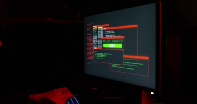 Shot of a young hacker cracking a computer code in the dark