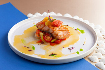 Salmon steak on a vegetable pillow. In a plate.