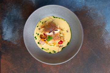 Fillet of white fish in a plate with sauce and vegetables. Selective focus