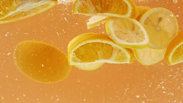 sliced lemons and oranges falling into fresh water