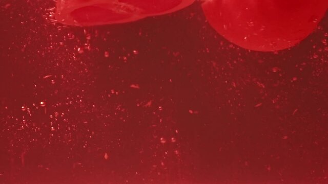 halves of grapefruits falling into fresh water on red