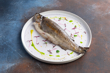 Cooked sea bass in a plate.