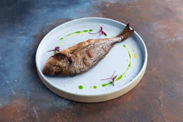 Fried dorado fish in a plate.