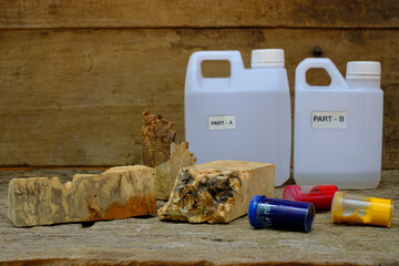 Timber burl woodchips color bottle and resin epoxy for casting wood on old wooden table background