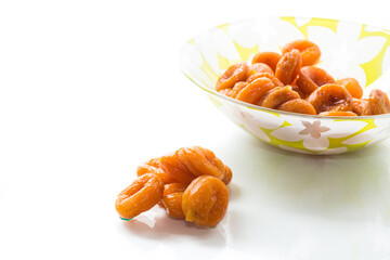 delicious dried apricots in a bowl on white background