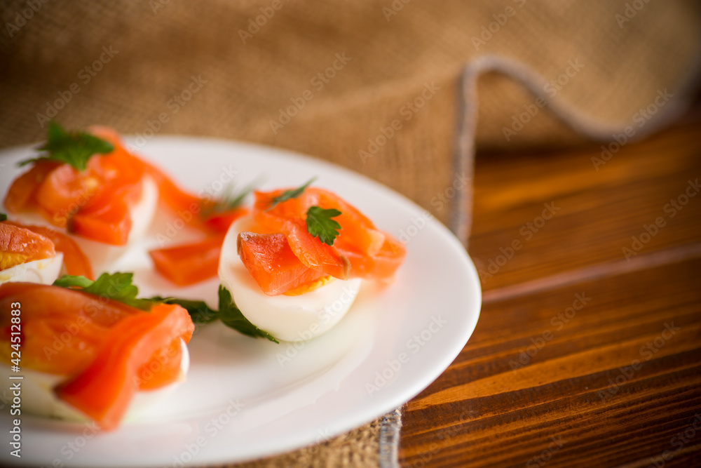 Wall mural halves of boiled eggs with pieces of salted salmon