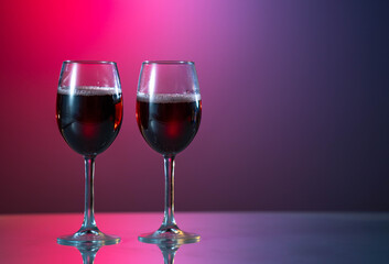 Two glasses of red wine and bottle on the fantastic great background