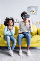 excited african american kid laughing near mother gesturing in vr headset © LIGHTFIELD STUDIOS