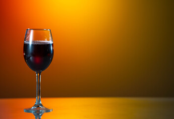 red wine is poured from a bottle into a glass. sunset