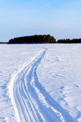 The road on the winter lake sunny winter day. space for copying text. Vertical photo