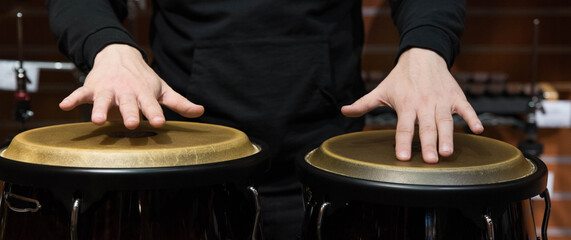 Professional percussion drum set closeup banner. Man drummer playing Conga Tumbadora percussion...