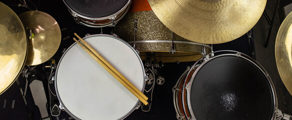 Plakat Musical instruments close up banner. Beautiful snare drum and hi-hat cymbals with drummer holding drumsticks. Modern drum set. Music shop.