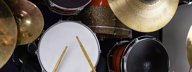 Musical instruments close up banner. Beautiful snare drum and hi-hat cymbals with drummer holding...