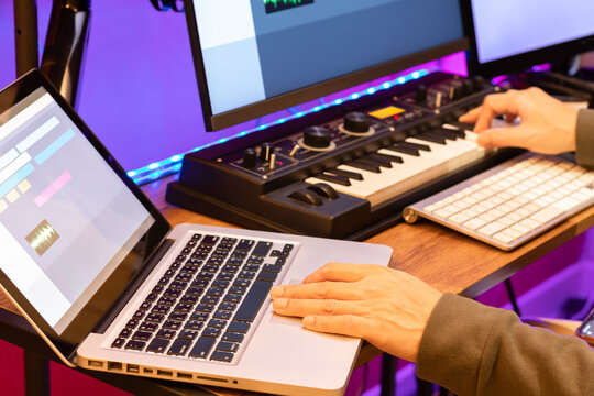 male composer, producer, arranger, song writer, musician hands arranging music on computer in home studio. music production concept