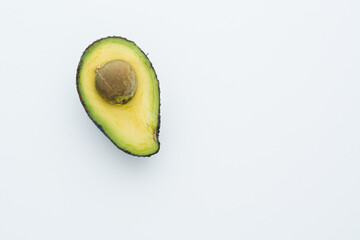avocado on the left of a  white board. Empty space