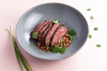 Sliced steak on a pillow of vegetables.