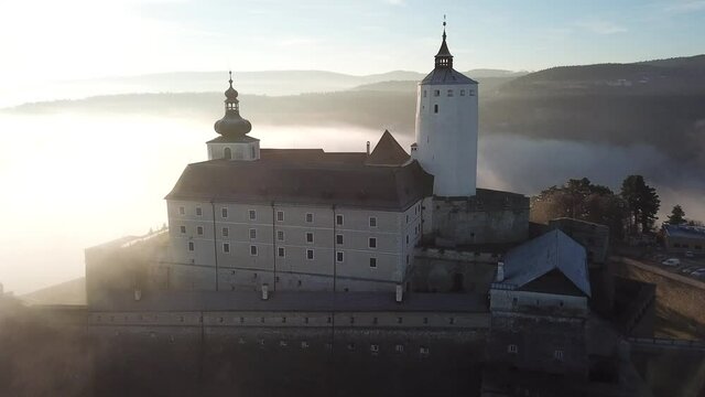 Cinematic foggy and cloudy bird's-eye aerial drone footage of the charming historical quaint old medieval European Burg Forchtenstein Castle in Burgenland Austria