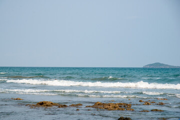 waving on beach with mountain so far blue sky