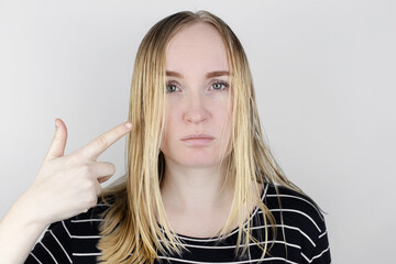 The girl looks in front of the mirror at her oily hair. Problematic scalp and increased secretion...