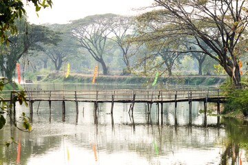Obraz premium morning in the park with Wooden bridge over the canal.