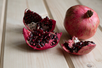 pomegranate fruits in a section on a light wooden surface