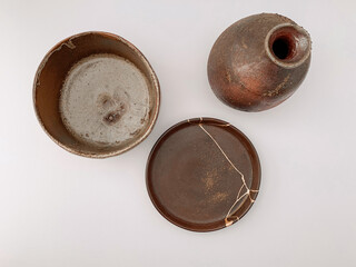 Brown Kintsugi pottery, bizen ware with gold scars repair
