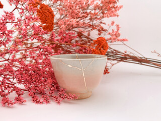 Kintsugi, Japanese Hanami flowers with real gold restored pottery, golden scarsa and cherry blossoms