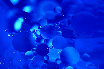 Abstract background with blue bubbles of oil in water. Macro photography. View from above.