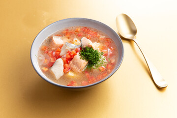 Traditional fish soup on a yellow background.