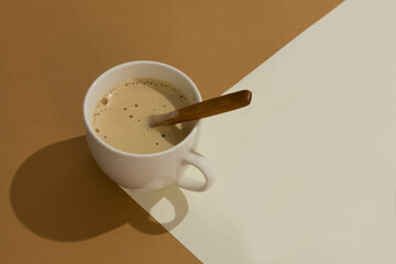 White cup with coffee latte on sandy beige isometric trendy background with hard shadow. Creative postcard