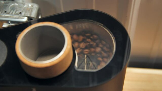 Coffee beans spinning in a drum roaster, slow motion close up